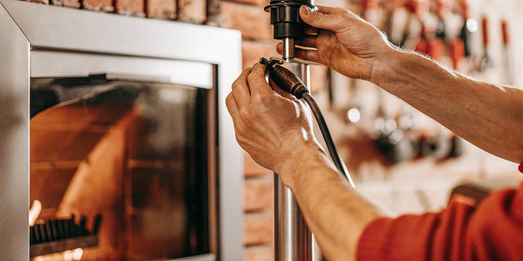A person installing a replacement auger motor in a pellet grill.