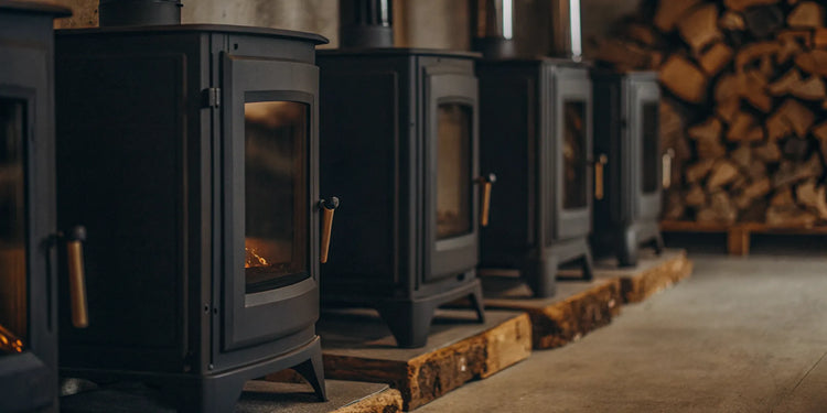 A row of catalytic wood stoves for sale on display in a showroom.