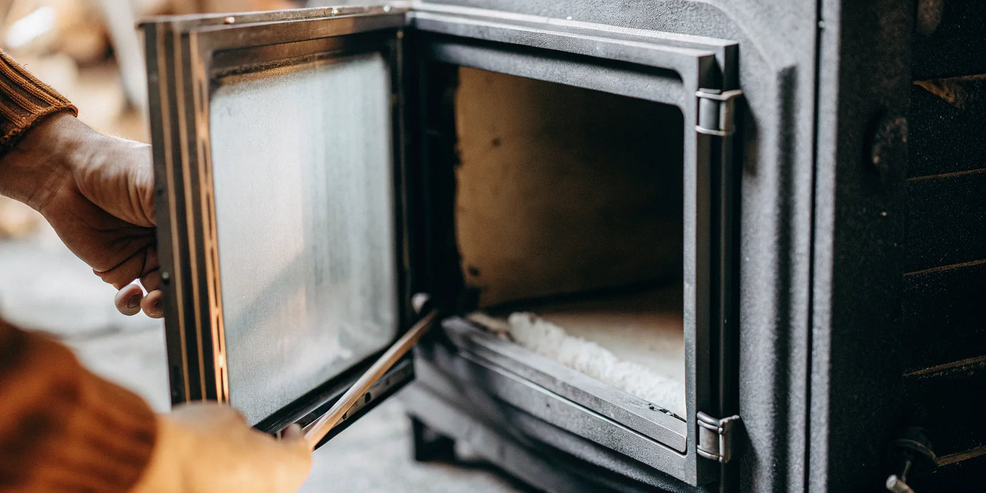 Opening a wood stove door to access the 1 inch gasket for replacement.