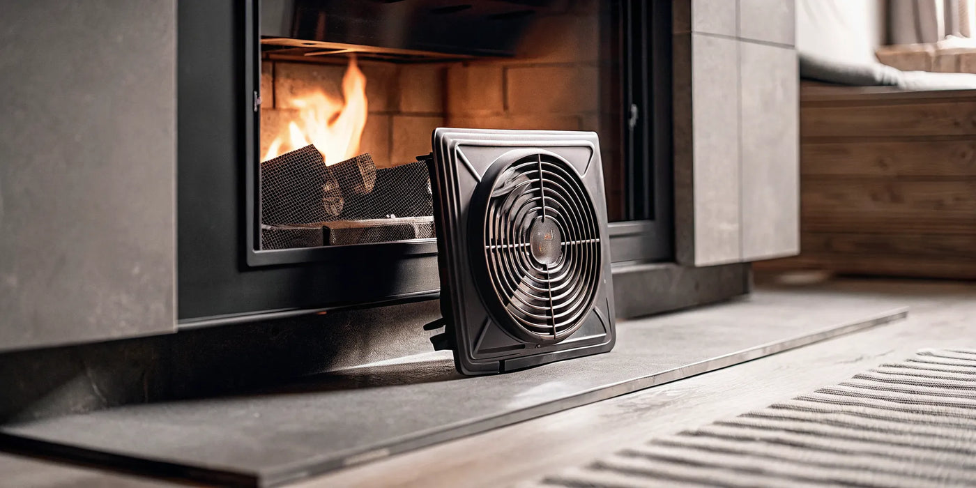A fireplace blower kit with its components ready to install at the base of a fireplace.
