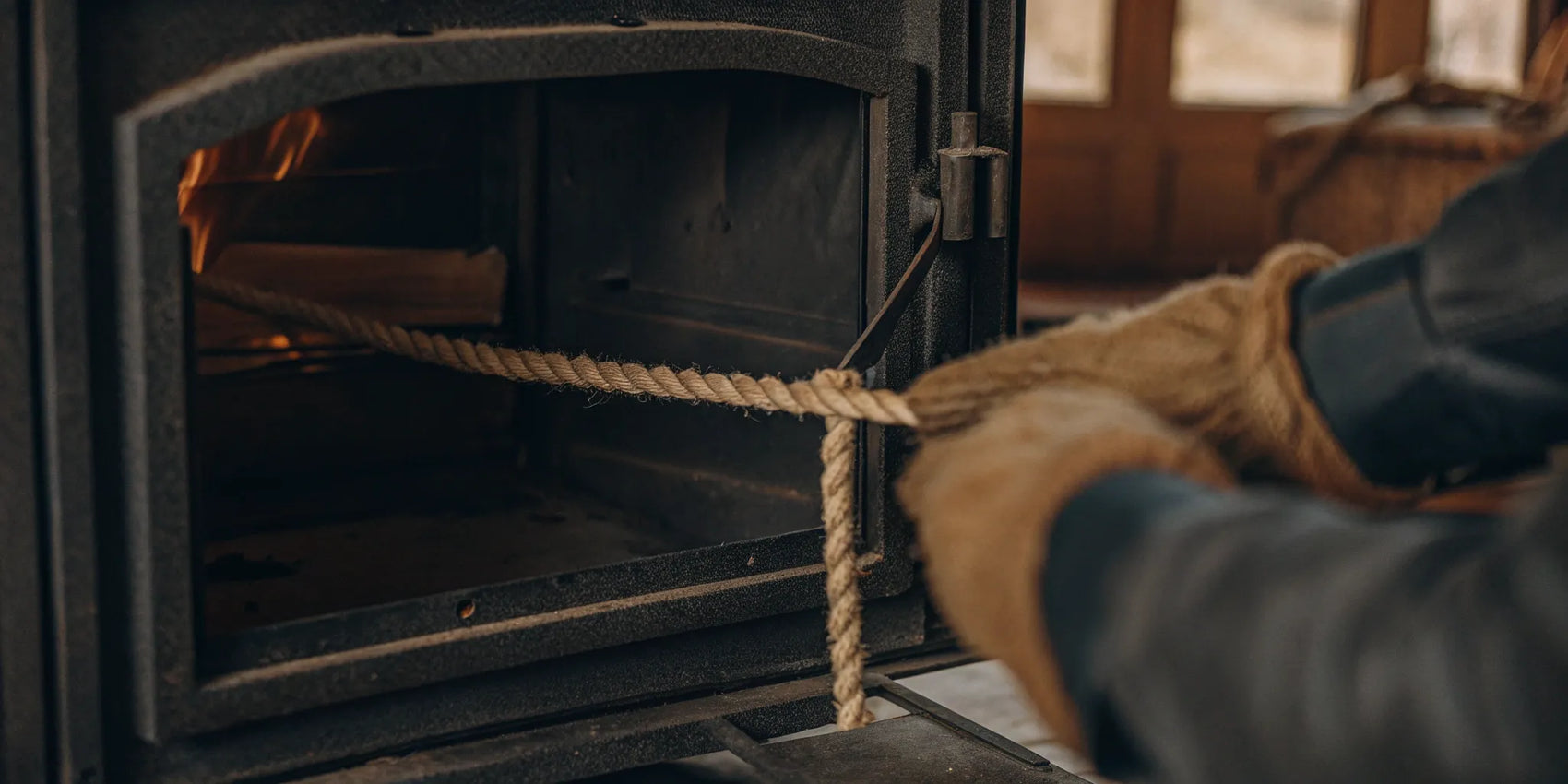 Installing a new rope seal on a wood stove door.