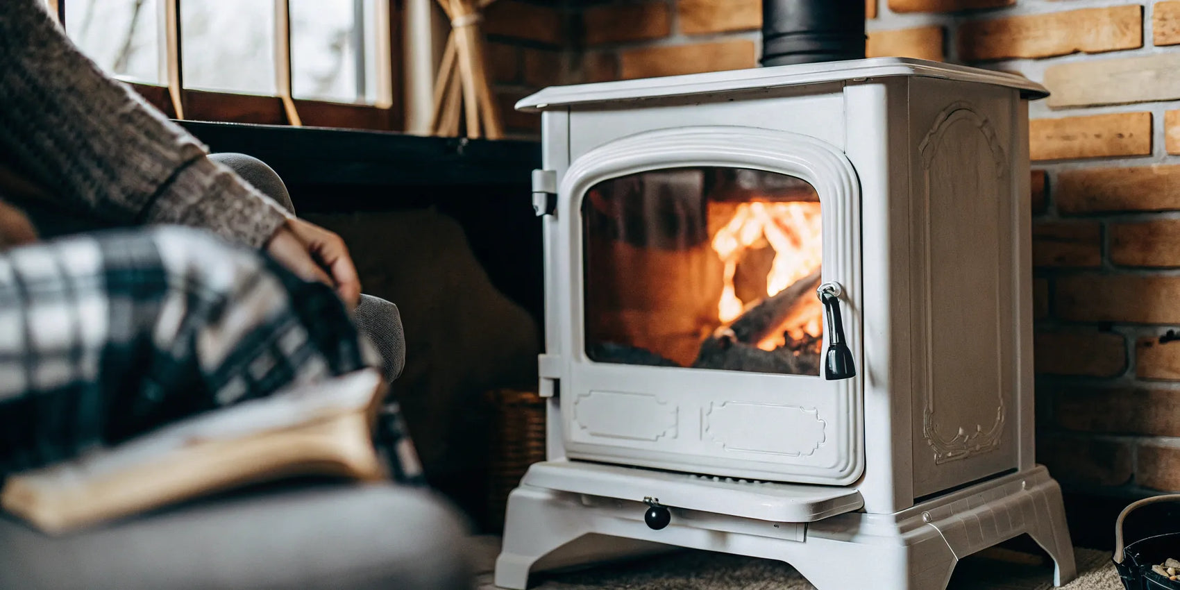 A fire burns brightly behind a wood stove's ceramic glass door, the focus of a glass replacement.