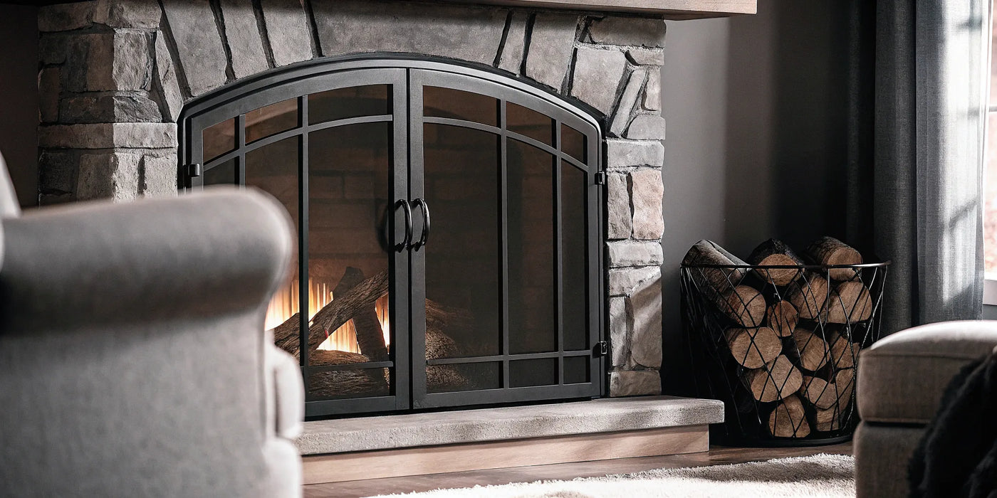 Modern black glass doors installed on a stone fireplace for safety and style.
