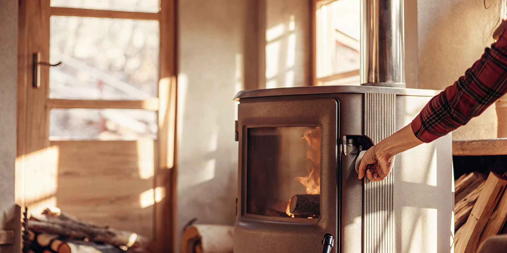 A hand inspecting the worn rope gasket on a wood stove door.